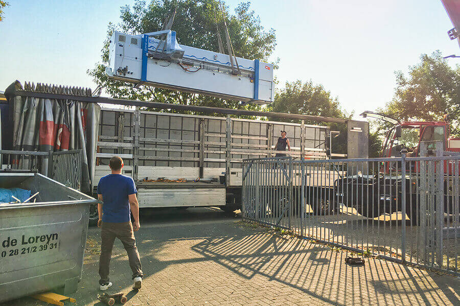 Lossen van de nieuwe platenzaag van S-Polytec met een autolaadkraan