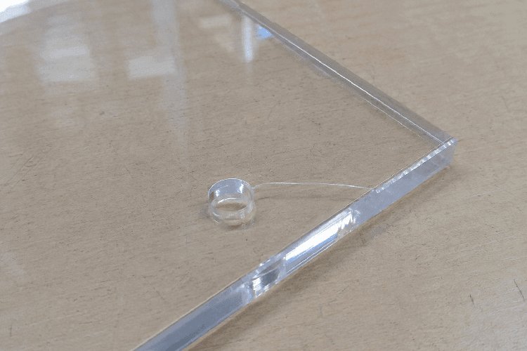 Scheur van een te klein boorgat tot aan de rand van een acrylglasplaat