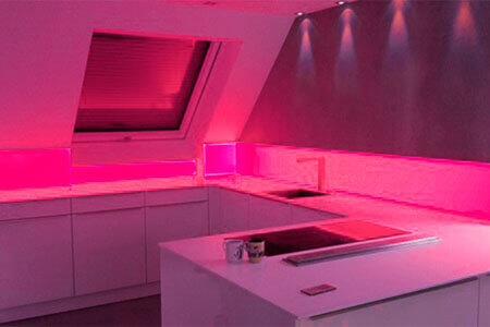 Een keukentje met spatbescherming van acrylglas met rode achtergrondverlichting